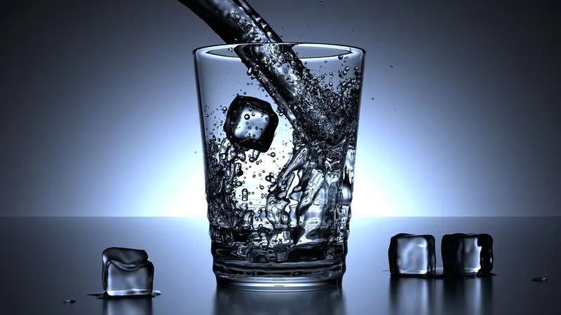 বরফের টুকরোর পাশে কাচের গ্লাসে ঢালা হচ্ছে ঠান্ডা পানি