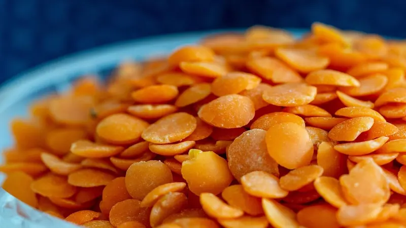 নীল বাটিতে রাখা কমলা রঙের মসুর ডালের দানা