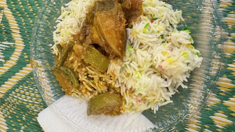 পাটির উপর রাখা প্লেটে সাদা ভাত আর মাছের তরকারি