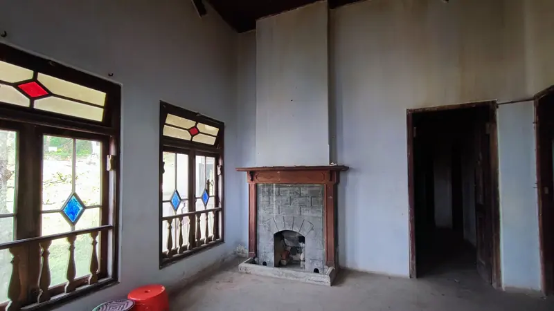 রঙিন কাচের জানালা, খোলা দরজা আর পুরনো ফায়ারপ্লেসসহ একটি পুরনো বাড়ির ফাঁকা ঘর